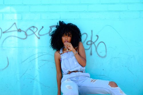 Frau mit Jeans und blaue Wand im Hintergrund