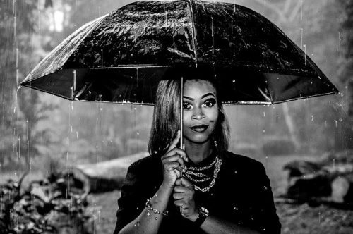 Woman unter einem Regenschirm mit Afrohaaren